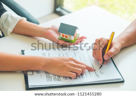 Women Real Estate Agent showing where to sign on document for buy house contract. Home loan contract, Real estate Concept