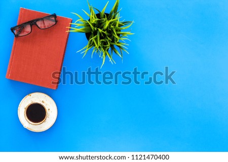 Reading for study and work. Self-education concept. business literature. Books with empty cover near glasses, coffe, plant on blue desk top view copy space