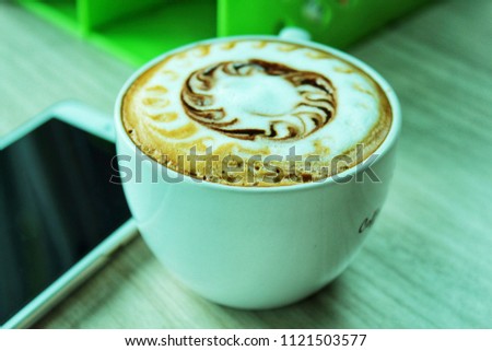 Hot coffee in white cup on wooden floor in the morning.