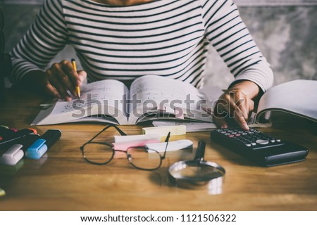 Young student sitting at desk in home studying and reading, doing homework and lesson practice preparing exam to entrance, education concept. Royalty-Free Stock Photo #1121506322