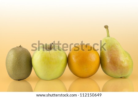 Group of various fruits like kiwi, apple, orange and pear on an orange background.