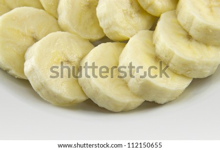 Close up of a banana slices with sugar on a white plate.
