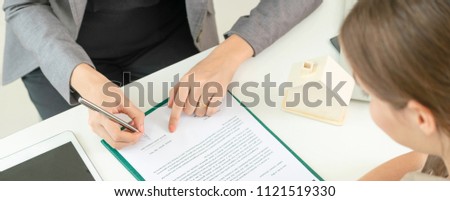 Client signs document regarding real estate activity next to lawyer or real estate agent sitting at office desk. Business concept of selling and buying house.