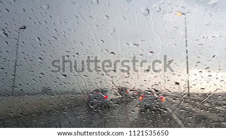Inside the car. Closeup rain water drops. car windshield view during rainy day on highway in the evening

