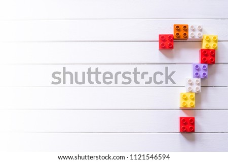 Question Mark.Colorful block toys arranged forming big Question Mark on white wooden table with copy space.