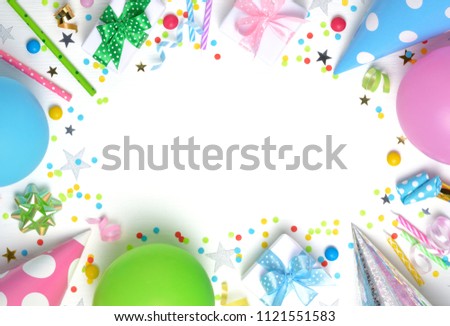 Holiday frame or background with colorful balloon, gift, confetti, silver star, carnival cap and streamer. Flat lay style. Birthday or party greeting card with copy space.