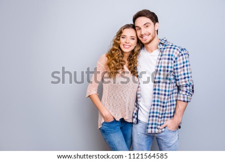 Portrait with copysapce empty place of attractive successful couple in casual outfits holding hands in pocket of pants hugging looking at camera isolated on grey background Royalty-Free Stock Photo #1121564585