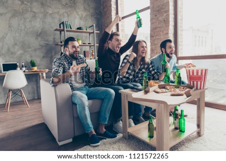 Four stylish, successful, attractive guys with raised arms, cheer for favorite team, watching football, basketball match together, yelling, drinking lager eating snacks, chips, popcorn, pizza