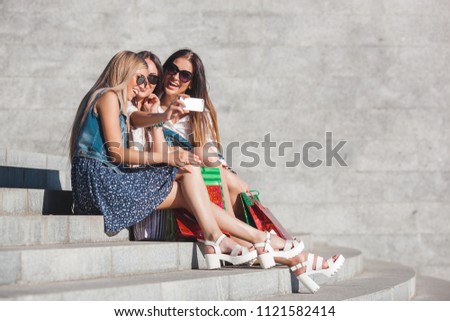 Pretty girlfriends making selfie and talking on cell phone