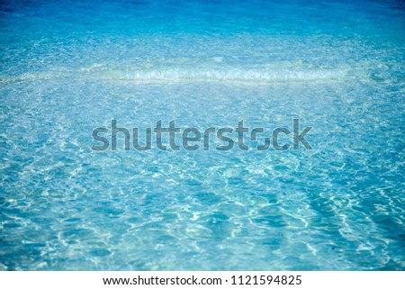 The shore of the ocean. Waves and sand of the ocean. Background. Blue water. Maldives Island. Maldive. Summer. May.