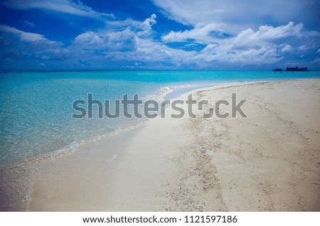 Maldive Islands. Summer. Ocean nirvana. Blue sky and clouds. Sandy shore. Maldive. Summer. The shore of the ocean. Waves and sand of the ocean. Background. Blue water. 