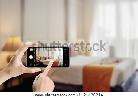 Close up of hands holding smartphone take photo bedroom at hotel