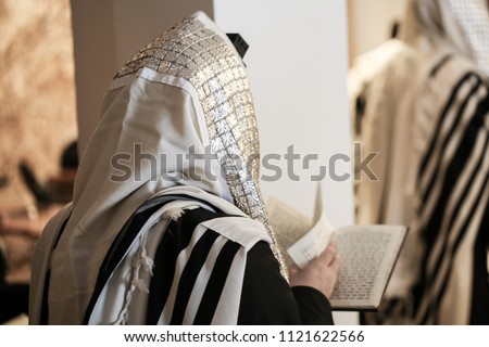 Jewish orthodox man wrapped in prayer shawl from a side view Royalty-Free Stock Photo #1121622566