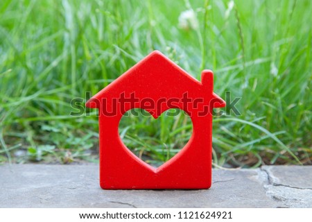 Sweet house in the grass. Concept of eco house, cottage. Symbol of  house with heart on green summer lawn