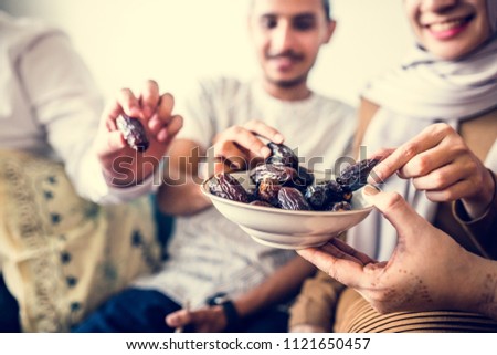 Muslim family having dried dates as a snack Royalty-Free Stock Photo #1121650457