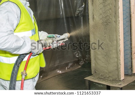 Covering a wall by fireproofe refractory composition. Royalty-Free Stock Photo #1121653337