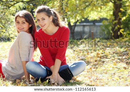 two young happy women on natural autumn background