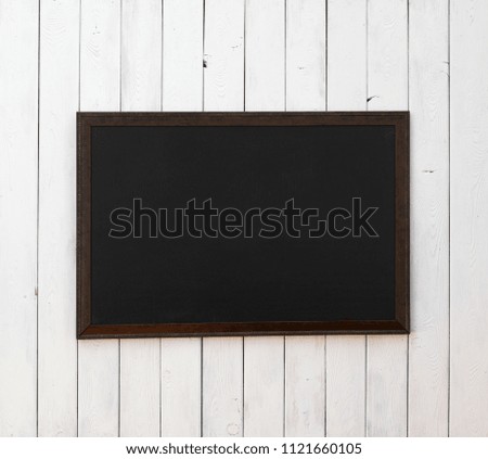 black wooden picture frame on a white wooden wall