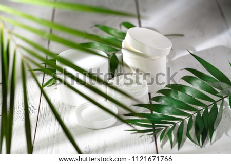 Cosmetic cream and beautiful spa containers on white table