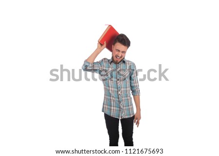 young angry man holding heavy book and screaming , isolated in white background Royalty-Free Stock Photo #1121675693