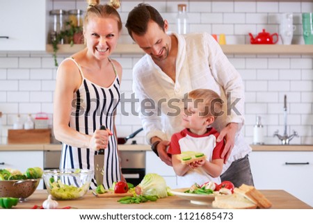 Image of parents and young son preparing food in kitchen