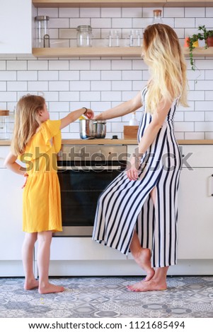 Portrait of mother and daughter cooking in kitchen