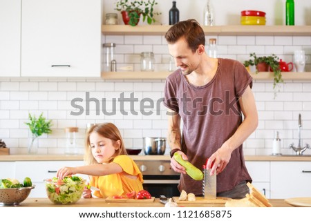 Photo of man with his daughter cooking dinner