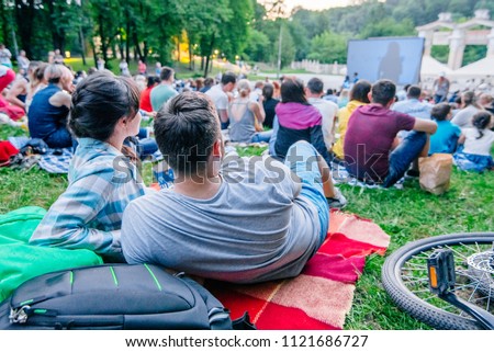 people watching movie in open air cinema in city park Royalty-Free Stock Photo #1121686727