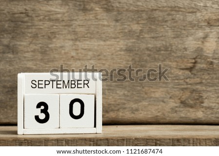 White block calendar present date 30 and month September on wood background