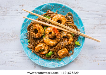 Teriyaki with shrimps with soba noodles and sesame seeds.
