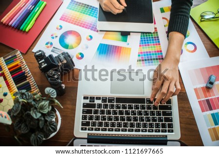 Professional Asian women Graphic designer using graphics tablet to do his work at desk. Architectural drawing with work tools and accessories.