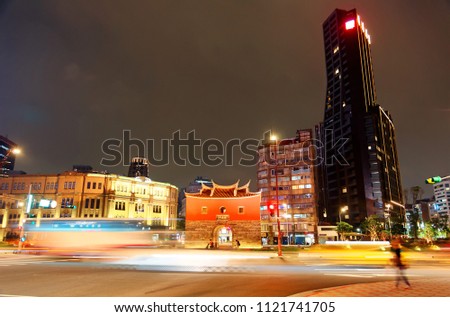 Night cityscape of Taipei, the vibrant capital city of Taiwan, with light trails of busy traffic dashing before the historical site North Gate among modern buildings and office towers