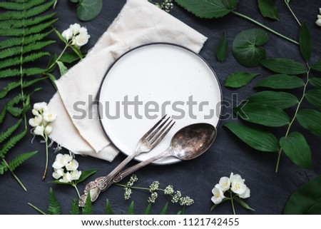 Beautiful boho spring table set up mockup with wild flower and plant decoration. Trendy flat lay top view photo.