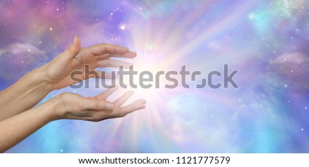 Cosmic Energy - female hands reaching into a bright white cosmic flash against a beautiful colourful night sky Universe background with copy space 
 Royalty-Free Stock Photo #1121777579