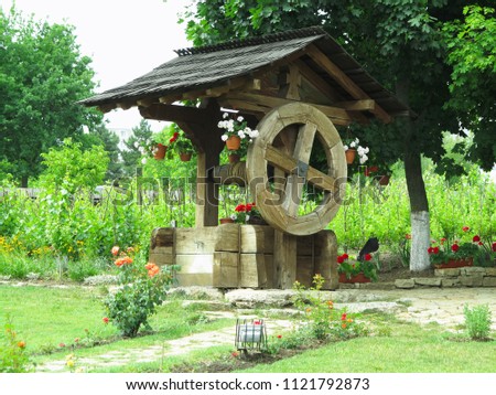 Vintage old wooden water well with huge giant wheel