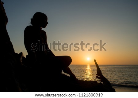 silhouette of a girl against the sunset and beautiful sea landscape