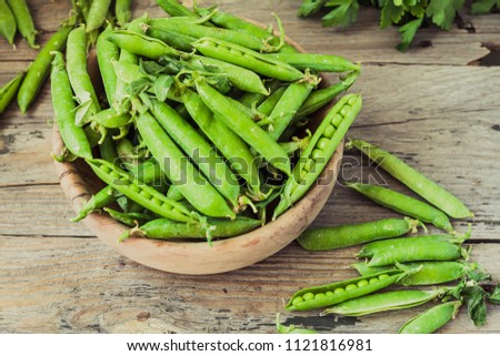 Green sweet peas pods on a gray wooden table. Vegetables.Detox diet and green summer food concept.Top view.