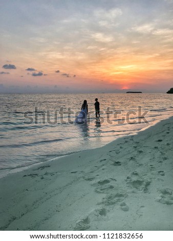 The image of two people in love at sunset on Fehendhoo island, Maldives