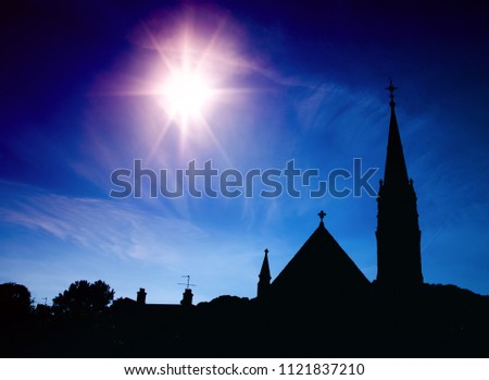 A colourful silhouette of an old church with spire.