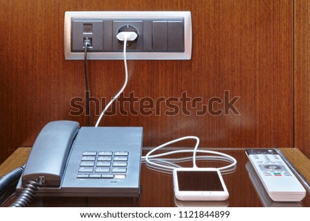 Loading smart phone. Hotel room desk. Travel business background. Equipment