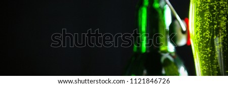 Close-up of green beer and bottle for St Patricks Day against black background