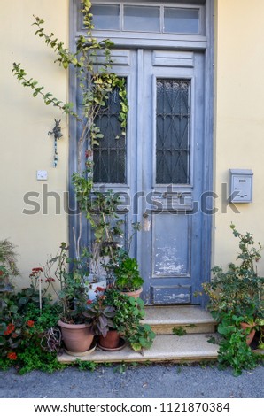 Blue door in Mediterranean style. Traditional greek door in Cyprus. Vintage background, texture. Copy space. Old wooden door in Nicosia, with green plants