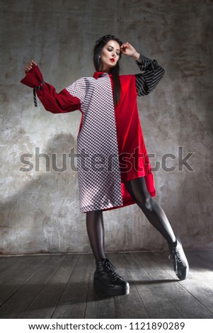 Attractive young woman showing designer clothes in studio. Fashion Collection