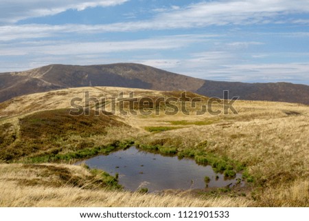 A small lake in the middle of a mountain range.