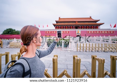 Enjoying vacation in China. Travel and technology. Young woman taking photo by smartphone in Forbidden City, Beijing.
