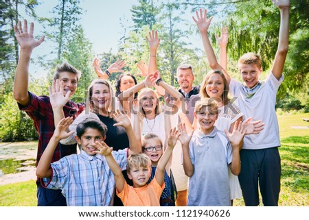 Portrait of happy foster family laughing in park Royalty-Free Stock Photo #1121940626