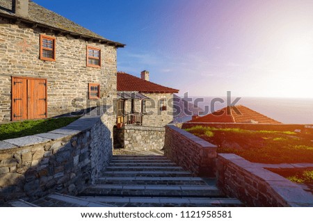 Old Greek houses with a tiled roof and sea view