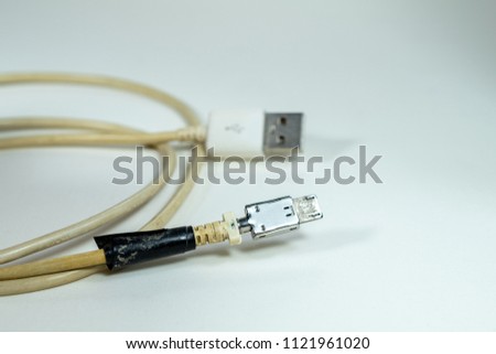 Damaged type B Micro USB cable with black tape, Defective charger wire of smartphone