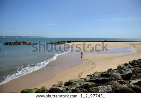 Beach of Paco de Arcos, Oeiras - Portugal - "Praia Velha" with a lonely fisherman in the sand