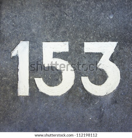 house number one hundred and fifty-three, engraved in natural stone and painted white.
